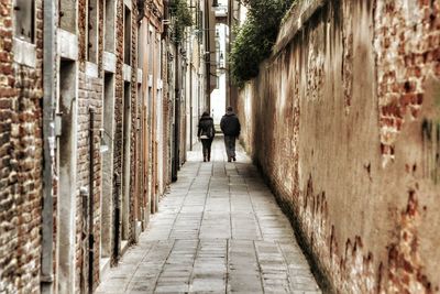Rear view of woman walking in alley