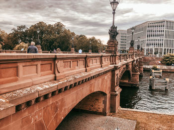 Bridge over river against buildings in city