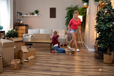 Full length of smiling young woman sitting on table