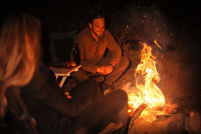 High angle view of man sitting by campfire