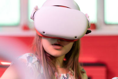 Vr game virtual reality. kid girl gamer playing on futuristic simulation video game in 3d glasses