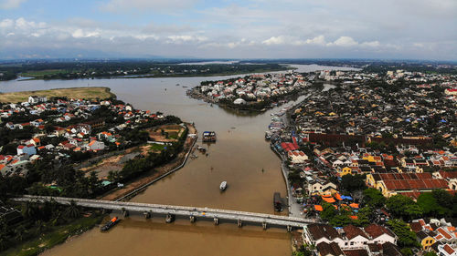 High angle view of townscape by river against sky