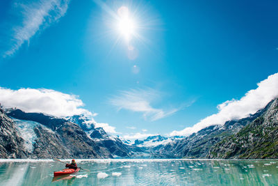 Woman kayaking in glacier bay national park with glacier in background