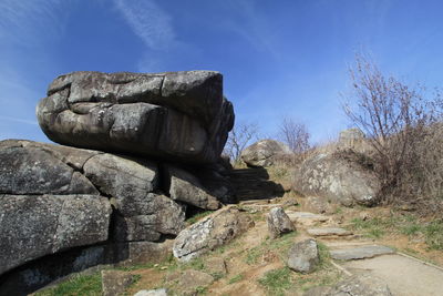 Rock formations on landscape against blue sky