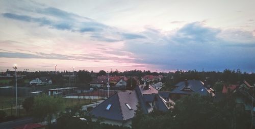 Cityscape against cloudy sky at sunset