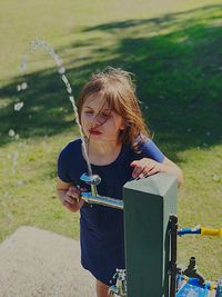 Girl drinking water from fountain