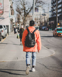 Rear view of man walking on road