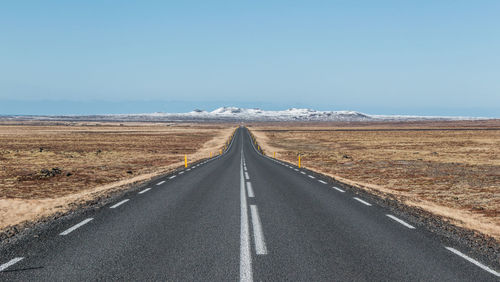 Road passing through landscape against clear sky