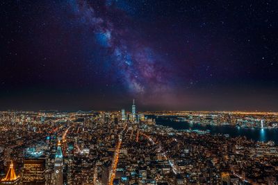 Illuminated cityscape against sky at night