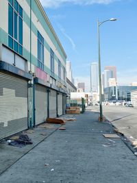 Empty street amidst buildings in city against sky