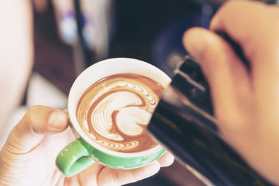 Close-up of hand holding coffee cup