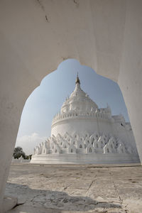 Low angle view of temple seen through arch against sky