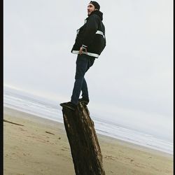 Man standing on beach against sky