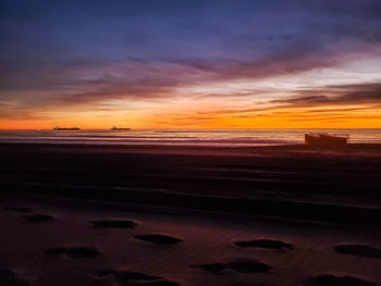 Scenic view of sea against dramatic sky during sunset