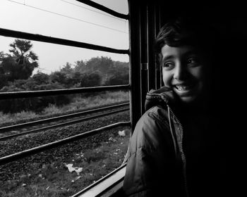 Smiling boy looking through train window