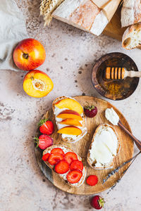 Open sandwiches with artisan bread and cream cheese, nectarines, strawberries and honey