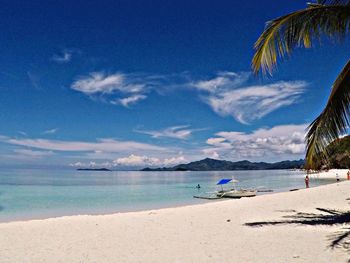 Scenic view of beach against blue sky