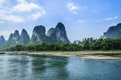 Scenic view of river and mountains against sky