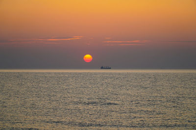 Scenic view of sea against orange sky