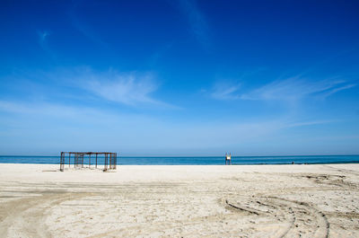 Scenic view of beach against blue sky