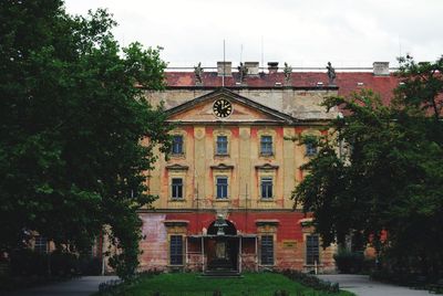 Building by trees against sky