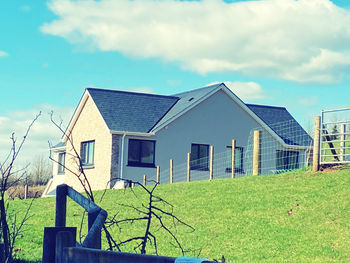 Houses on field against sky