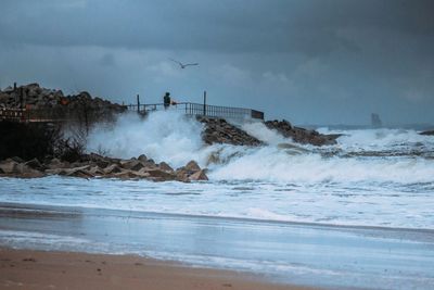 Waves splashing in sea against sky