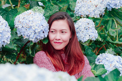 Portrait of beautiful young woman with red flowers