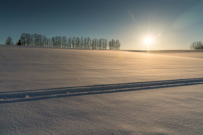 Scenic view of snow field against sky during sunset
