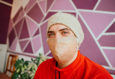 Portrait of man wearing mask and knit at home