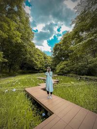 Full length of man sitting on grass against sky