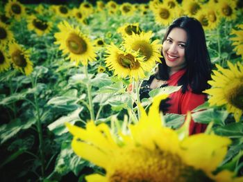 Portrait of smiling woman in sunflower field