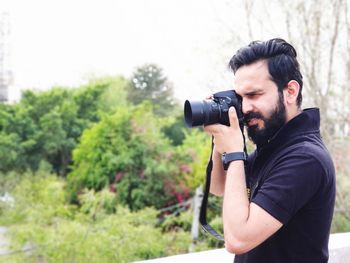 Young man photographing camera