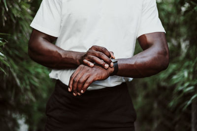 Midsection of man holding woman standing against blurred background