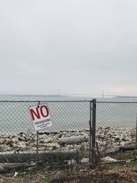 Information sign on field against sky