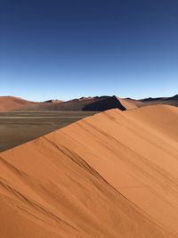 Scenic view of desert against clear blue sky