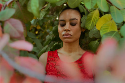 Portrait of young woman with green leaves