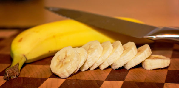Bananas with knife on cutting board