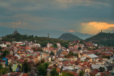 Houses in town against sky during sunset