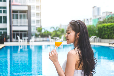 Woman drinking water in swimming pool