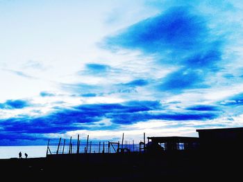 Silhouette of building against cloudy sky