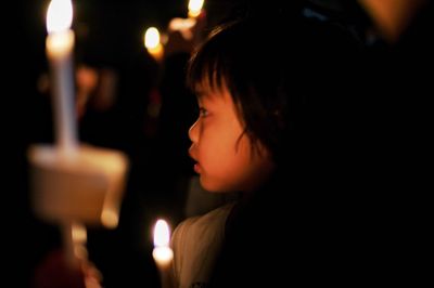 Close-up portrait of boy looking away at night