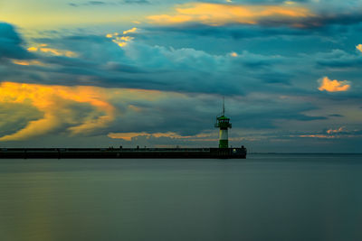 Silhouette of tower against cloudy sky