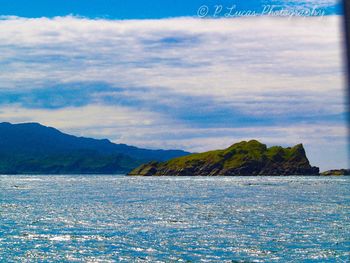 Scenic view of sea and mountains against sky