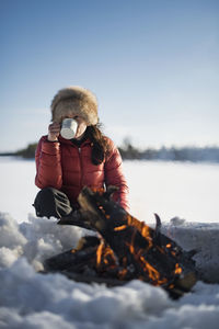 Woman sitting near campfire