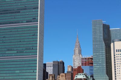 Skyscrapers in city against blue sky