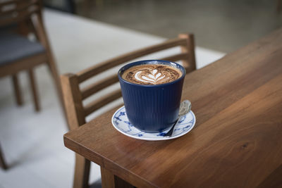 Close-up of coffee cup on wooden table