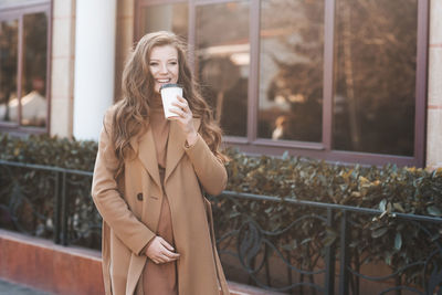 Pregnant woman drinking coffee on street