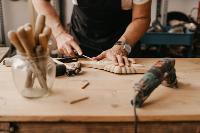 Midsection of man working on table