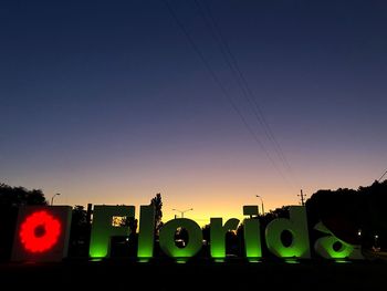 Low angle view of illuminated building against sky at sunset